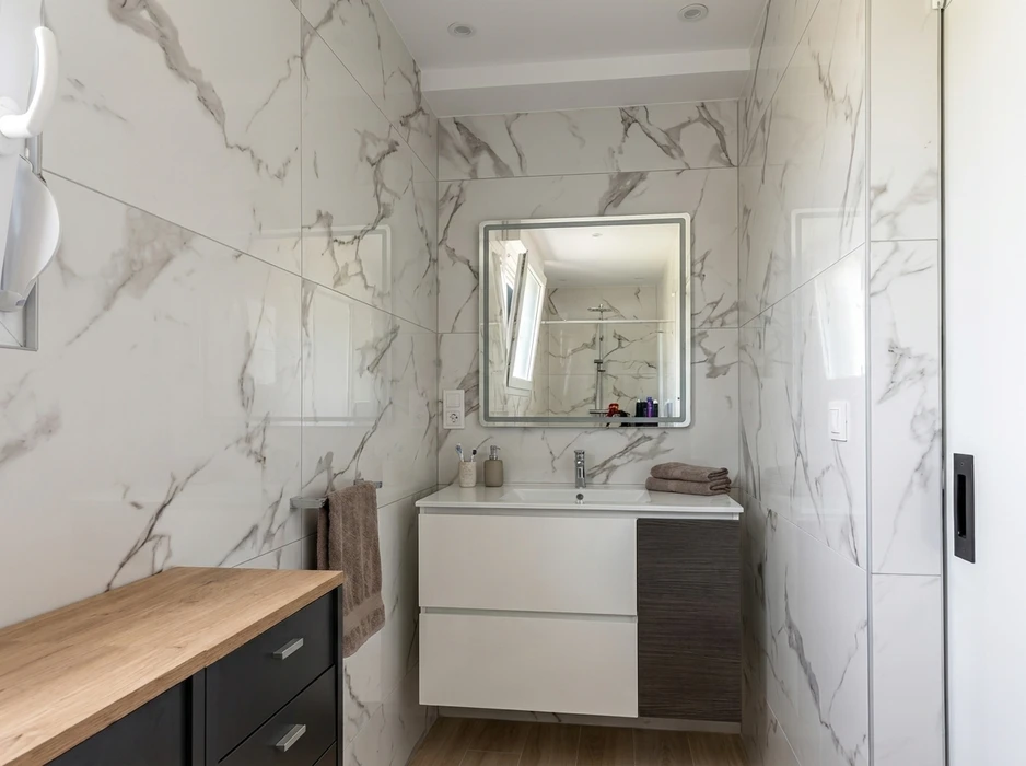 Salle de bain moderne avec carrelage grand format effet marbre blanc veiné