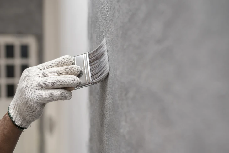 Intérieur en cours de rénovation avec artisan peintre appliquant de la peinture murale