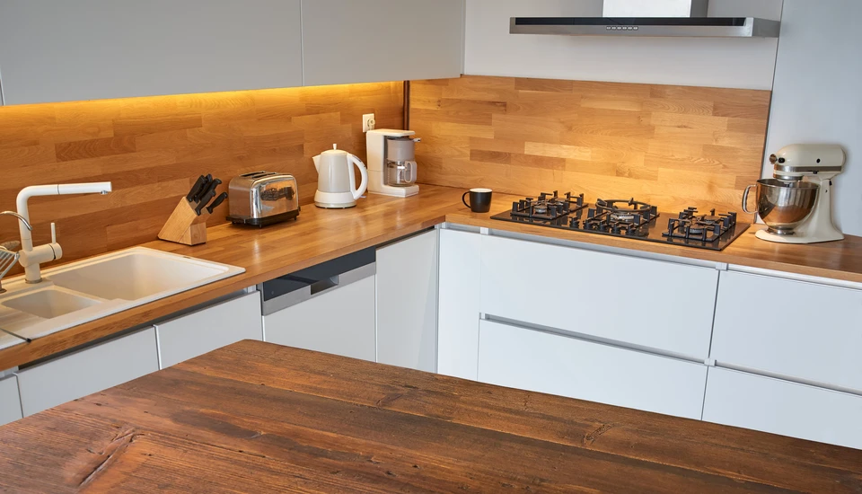 Cuisine moderne avec plan de travail en bois massif lamell&eacute;-coll&eacute; et fa&ccedil;ades laqu&eacute;es blanches