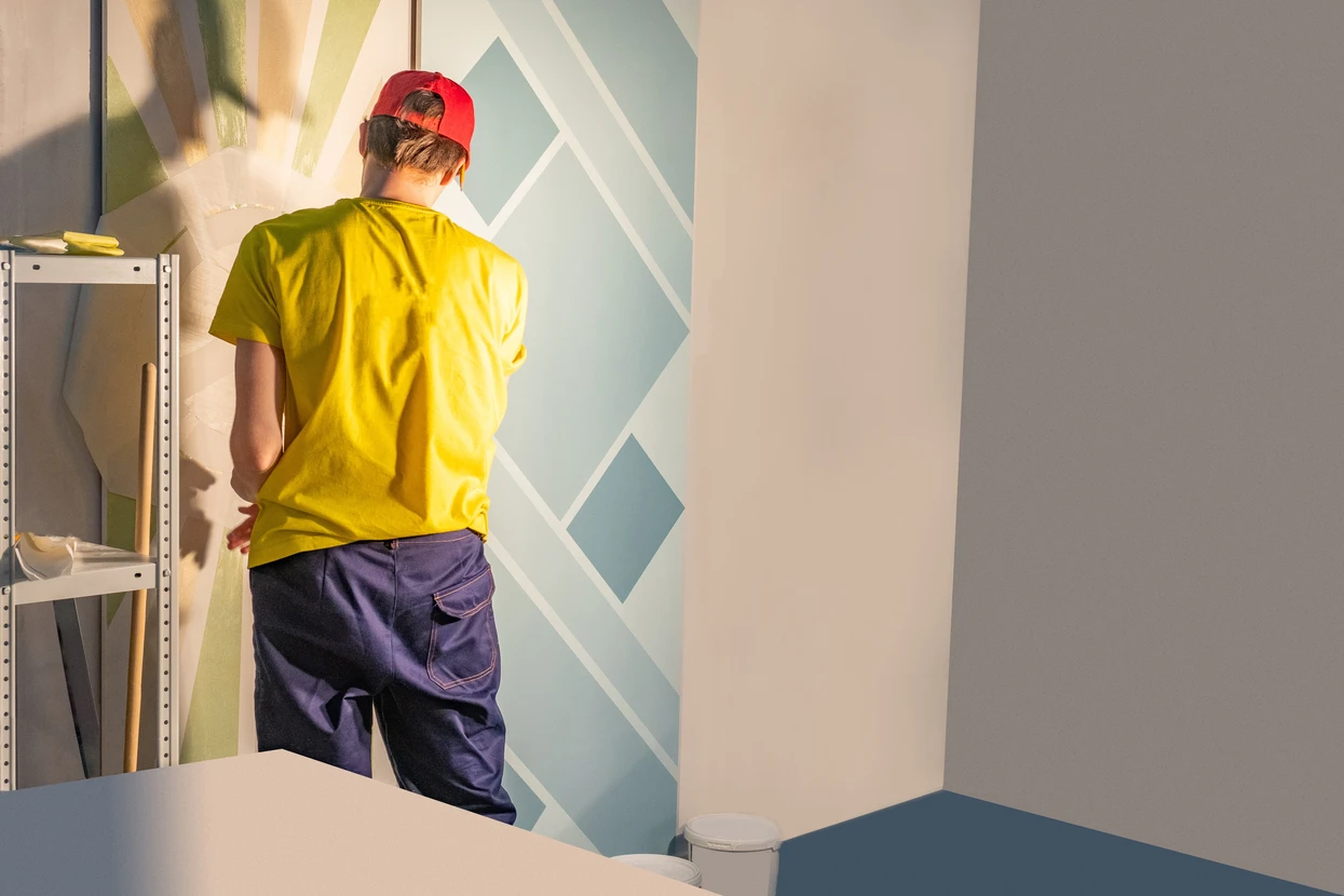 Intérieur en cours de rénovation avec artisan peintre appliquant de la peinture murale
