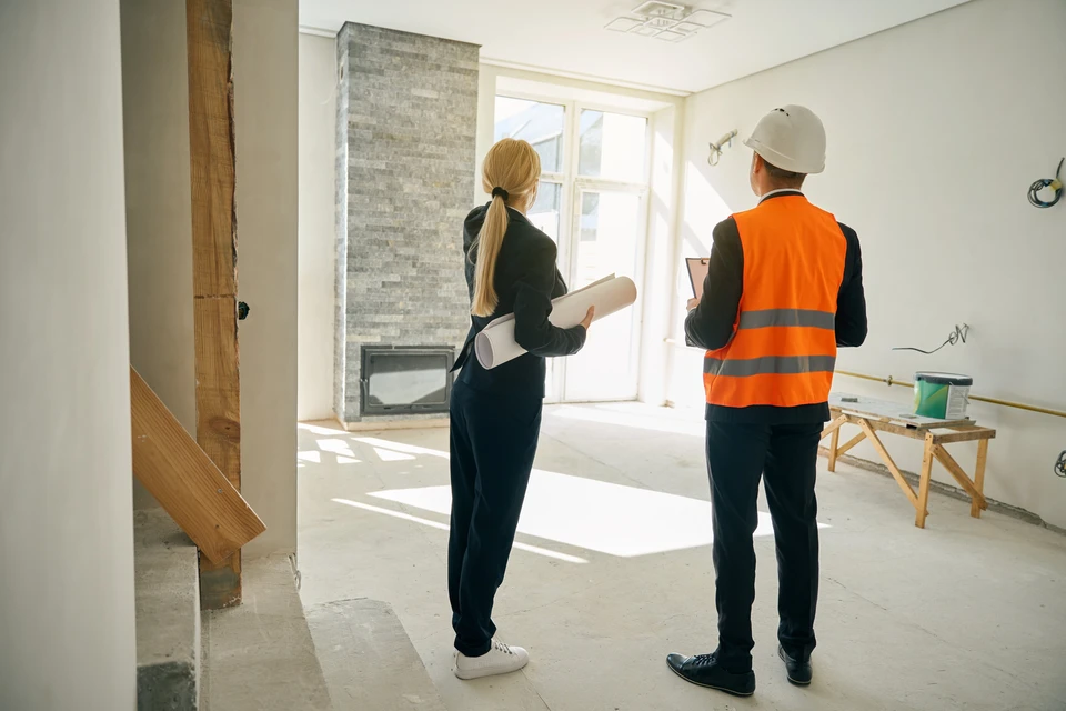 Homme effectuant des travaux de rénovation dans une cuisine, utilisant un niveau à bulle jaune pour vérifier l'alignement d'un meuble