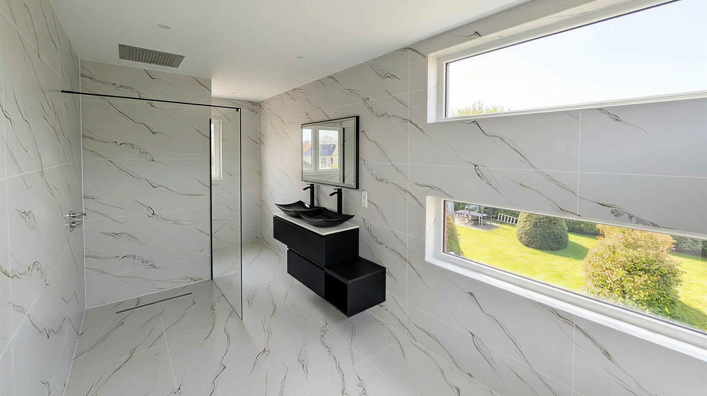 Cuisine moderne ouverte avec &icirc;lot central, plan de travail en quartz blanc, mobilier laqu&eacute; gris anthracite